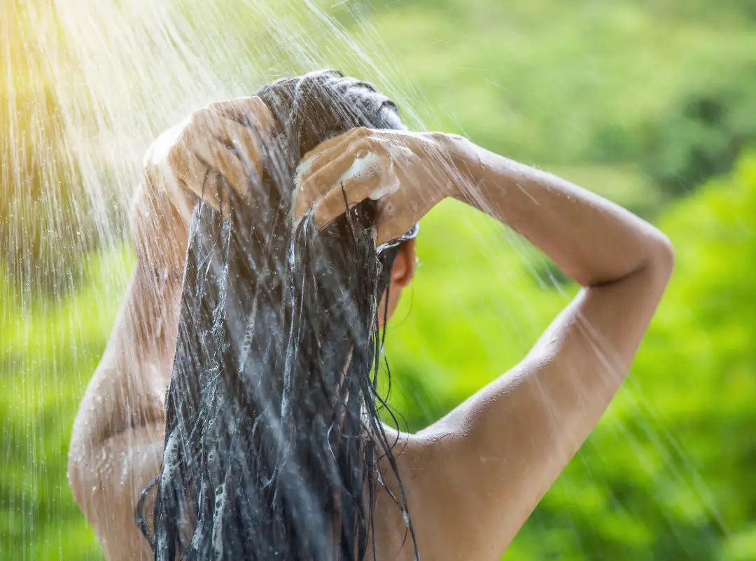Frau wäscht langes, dunkles Haar in Natürliche Haarpflege Collection