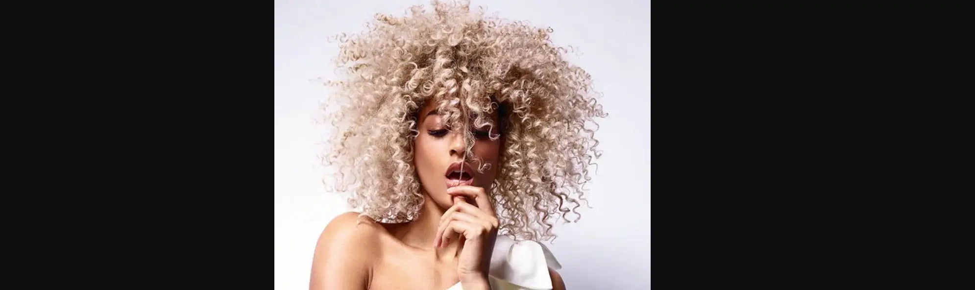 Model mit blonden lockigen Haaren im Schwarzkopf Haaröl Collection